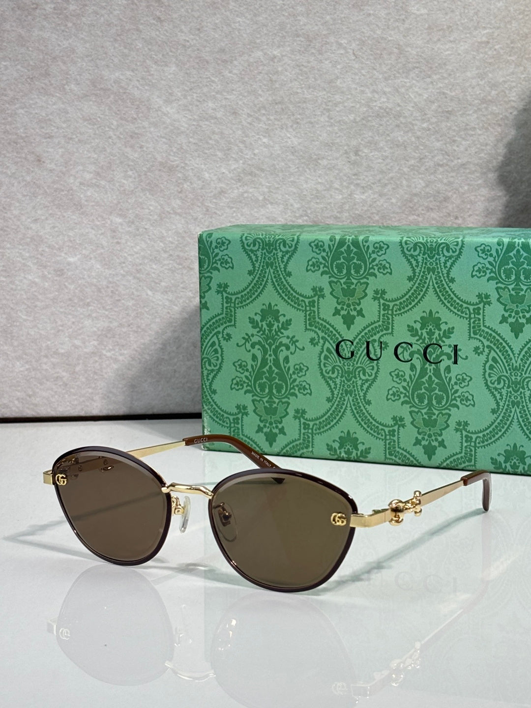 Gold metal sunglasses with dark brown lenses and chain-link temple details