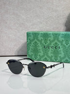 Gold metal sunglasses with black lenses and chain-link temple details