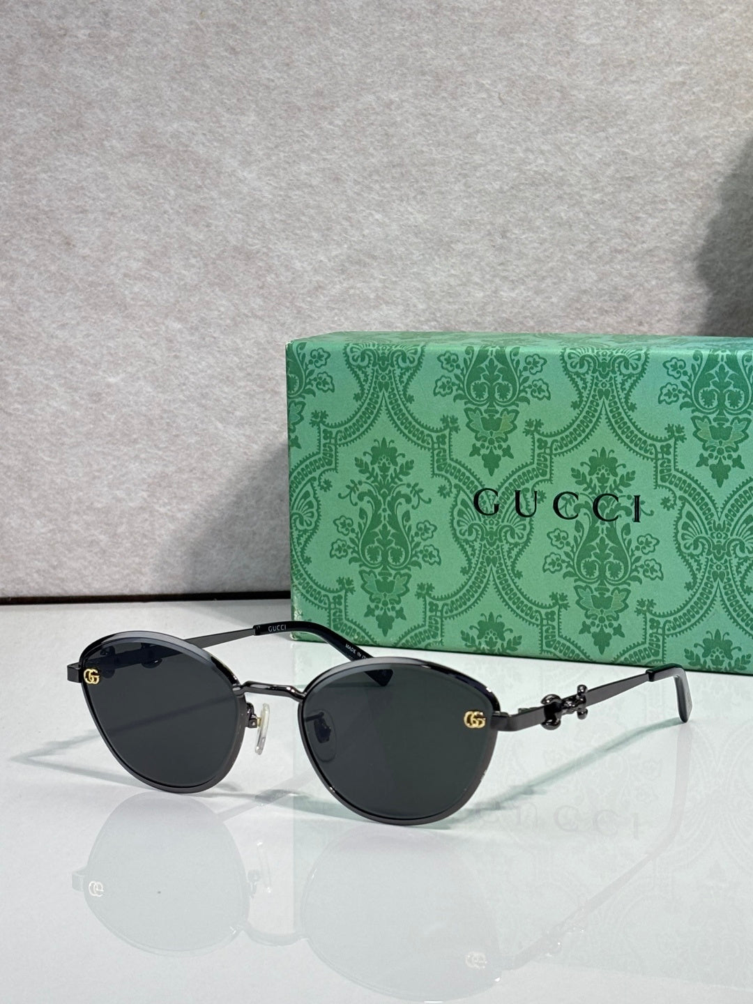 Gold metal sunglasses with black lenses and chain-link temple details