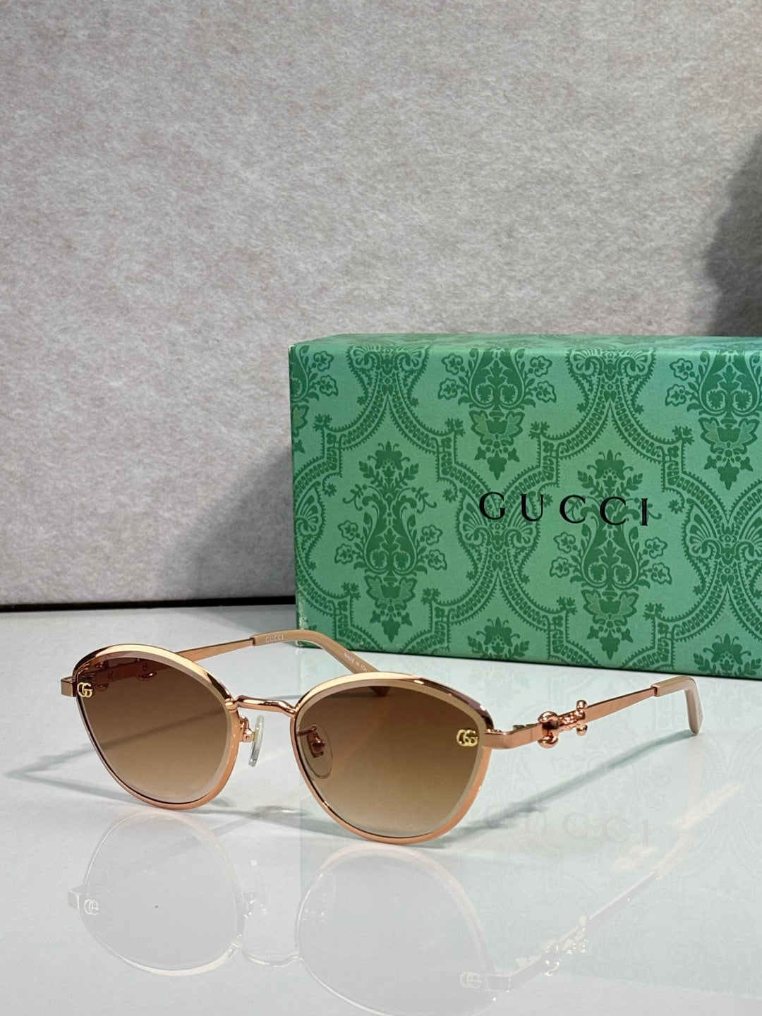 Gold metal sunglasses with light brown lenses and chain-link temple details