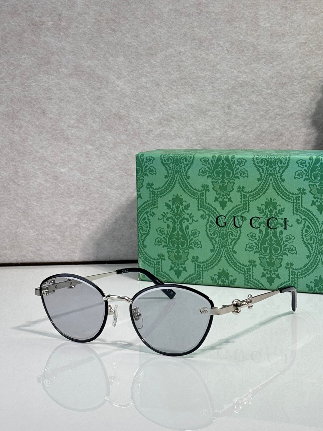 Silver metal sunglasses with dark lenses and chain-link temple details