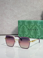 Gucci sunglasses with magenta frames and pink gradient lenses, square corners.