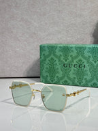 Gucci sunglasses with white frames and light green gradient lenses, square corners.