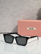 Rectangular dark-tinted sunglasses with black frame and gold side accents