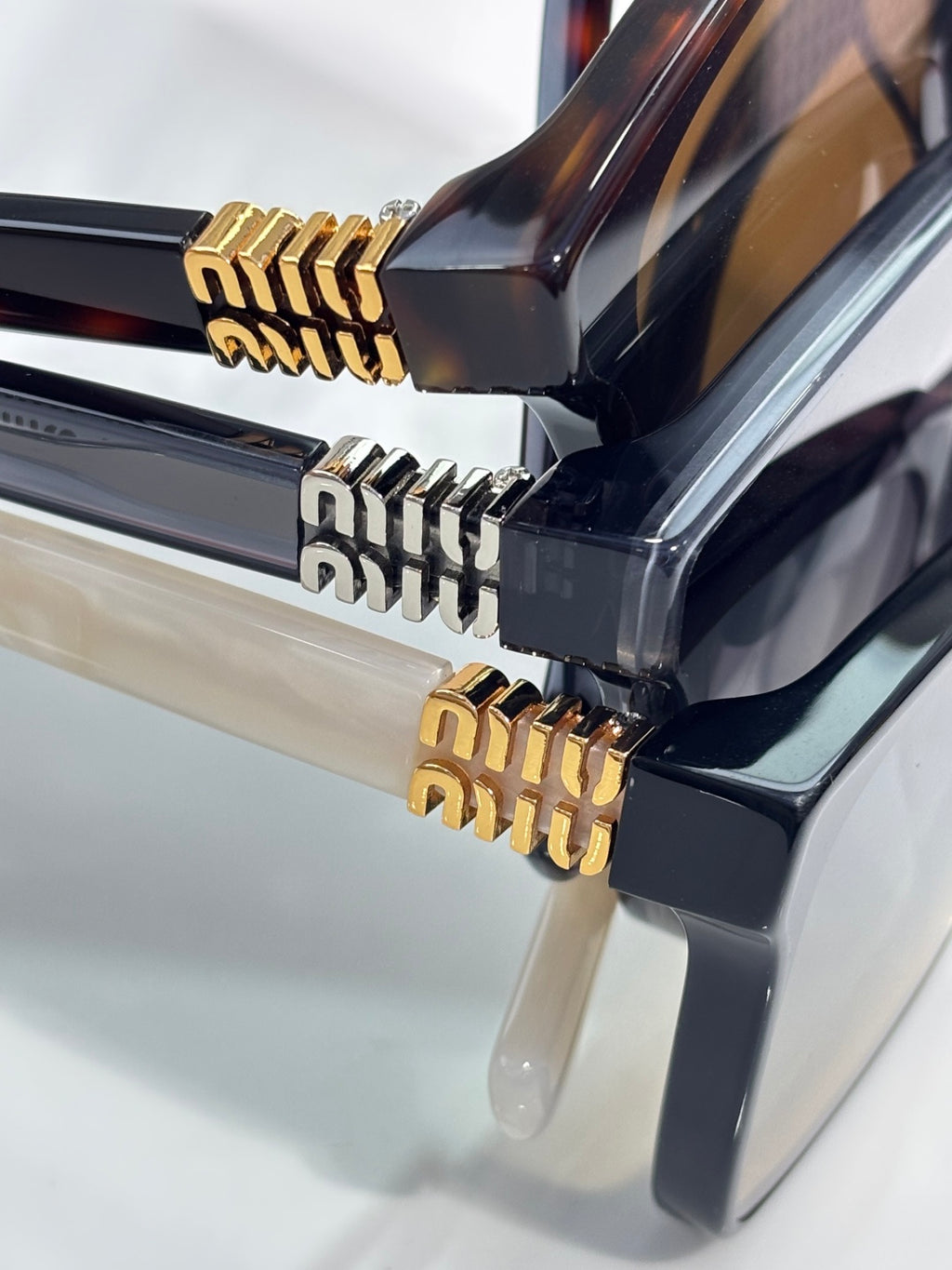 Sunglasses hinge detail with black frame and gold geometric metal accents