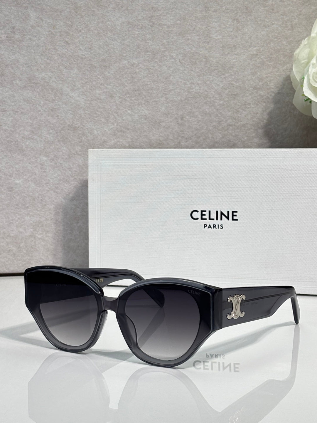 Celine sunglasses with glossy black frames, gold Celine logo on temple, dark lenses.