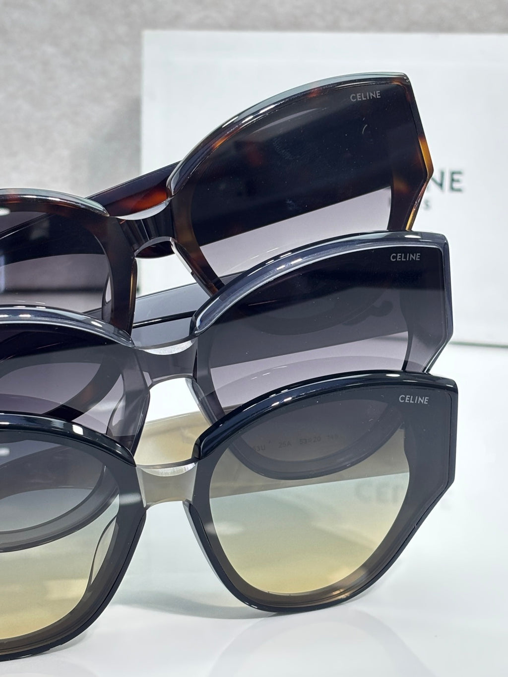 Celine sunglasses with mixed dark frames and tinted lenses, layered close-up view.