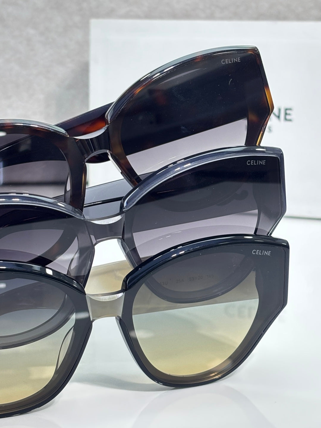 Celine sunglasses with mixed dark frames and tinted lenses, layered close-up view.