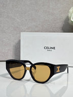 Celine sunglasses with black frames and warm amber lenses, gold logo on temple.