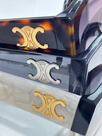 Celine sunglasses temple detail set with gold and silver logo emblems on frames.