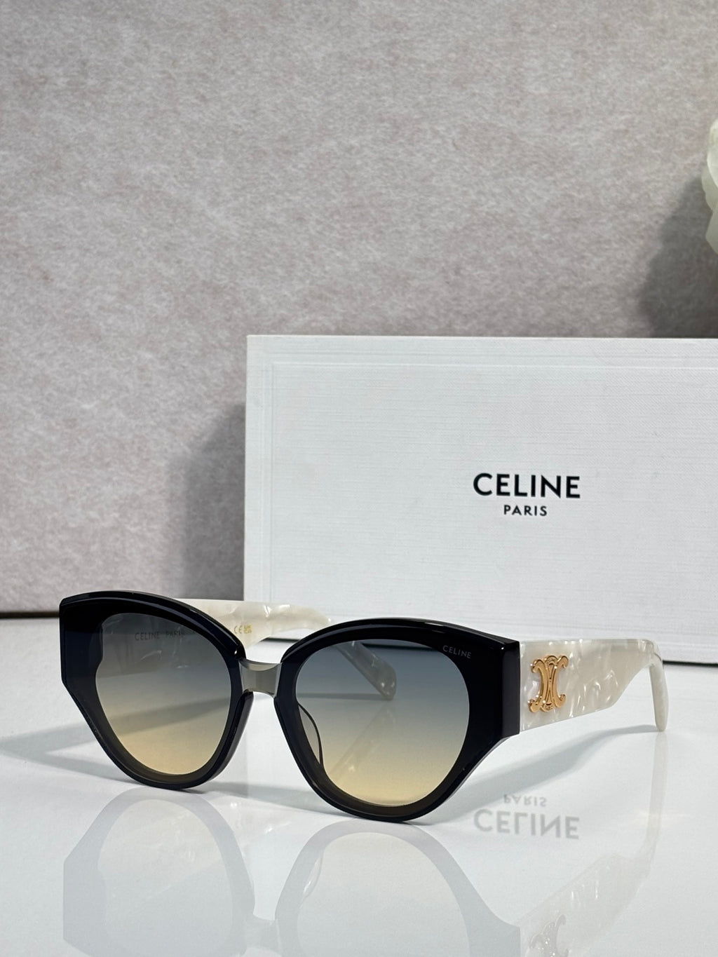 Celine sunglasses with black frames, lighter amber lenses, gold logo on temple.