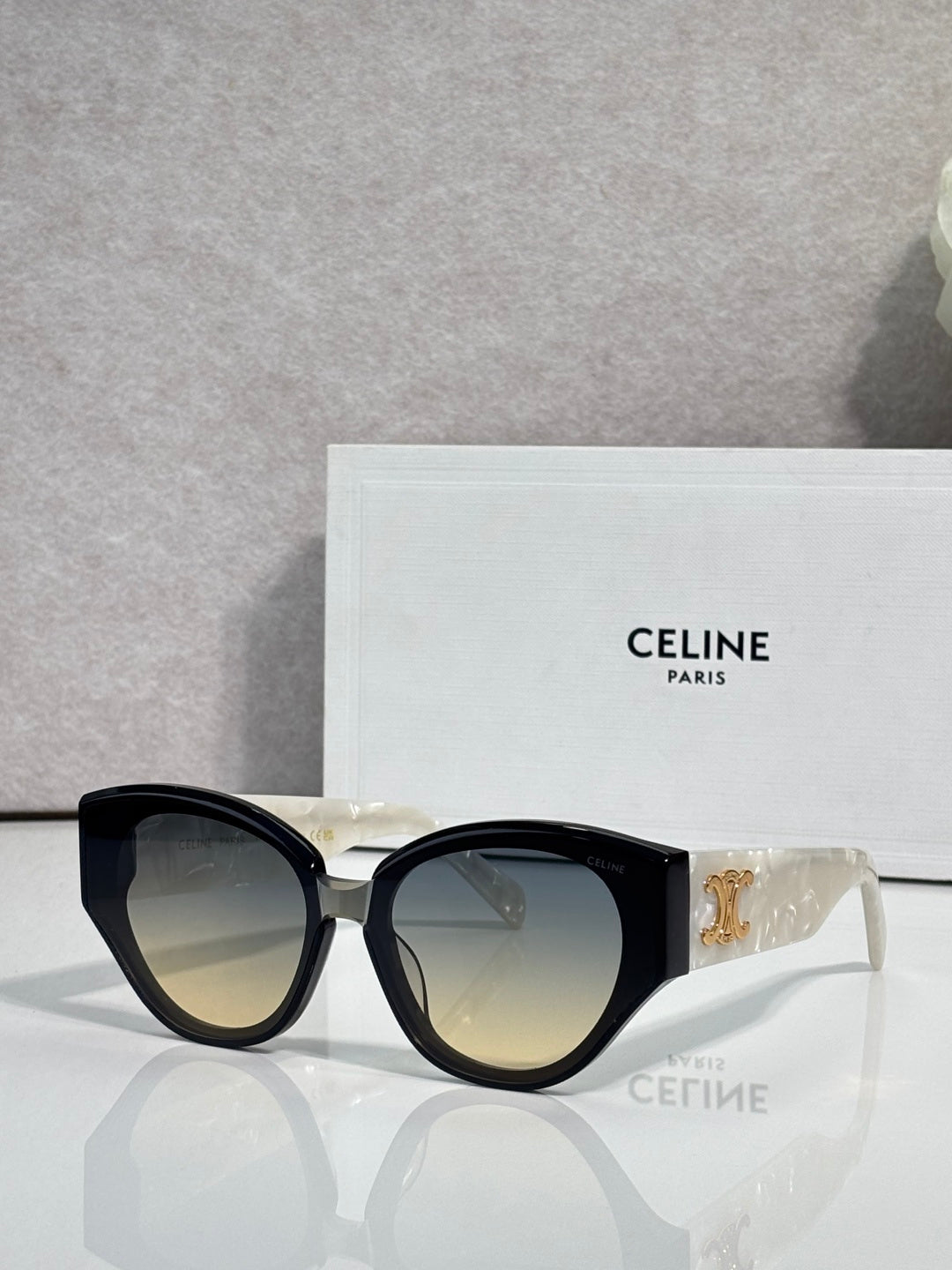 Celine sunglasses with black frames, lighter amber lenses, gold logo on temple.