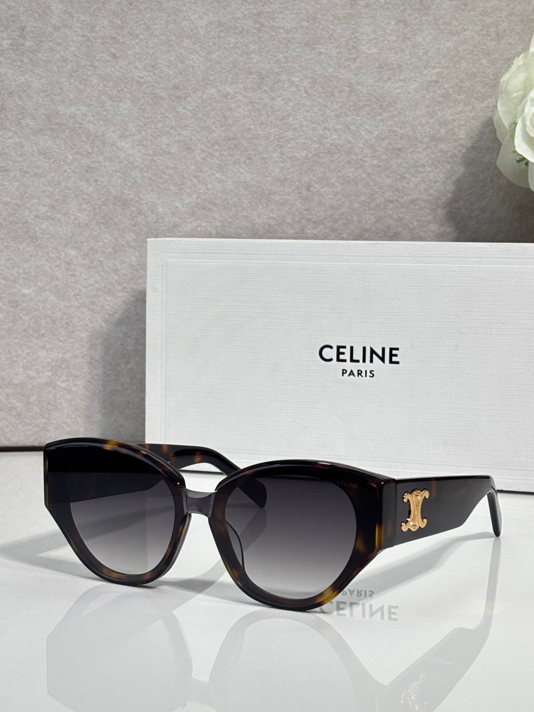Celine sunglasses with black frames and amber gradient lenses, gold logo on temple.