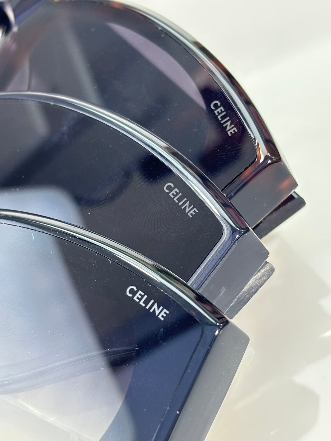 Celine sunglasses temple close-up with engraved brand text on dark tortoiseshell.