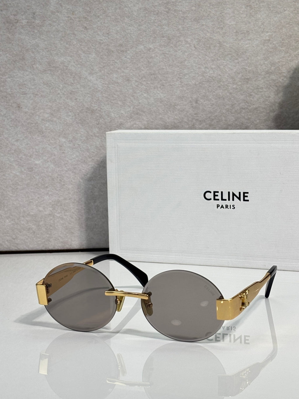 Celine sunglasses with round gray lenses and black frame, gold-tone temple arms