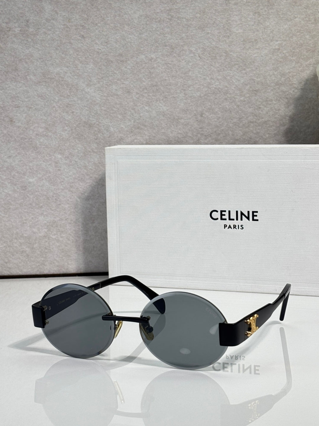 Celine sunglasses with round dark lenses and black frame, gold-tone hinge details