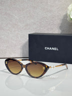 Chanel sunglasses with brown lenses and tortoiseshell frames, gold-tone logo detail