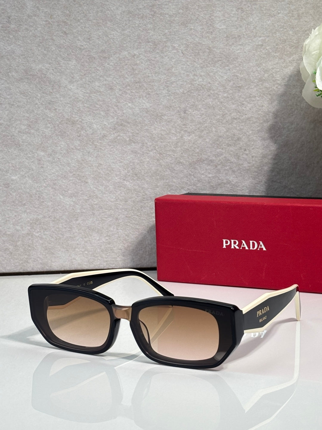 Prada sunglasses with dark tortoise frame and neutral-tinted lenses, cat-eye style