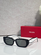 Prada sunglasses with black frame and dark tinted lenses, oversized cat-eye style