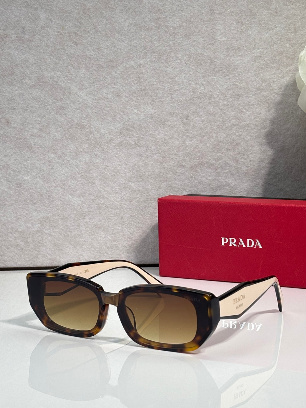Prada sunglasses with tortoise frame and dark tinted lenses, oversized cat-eye style