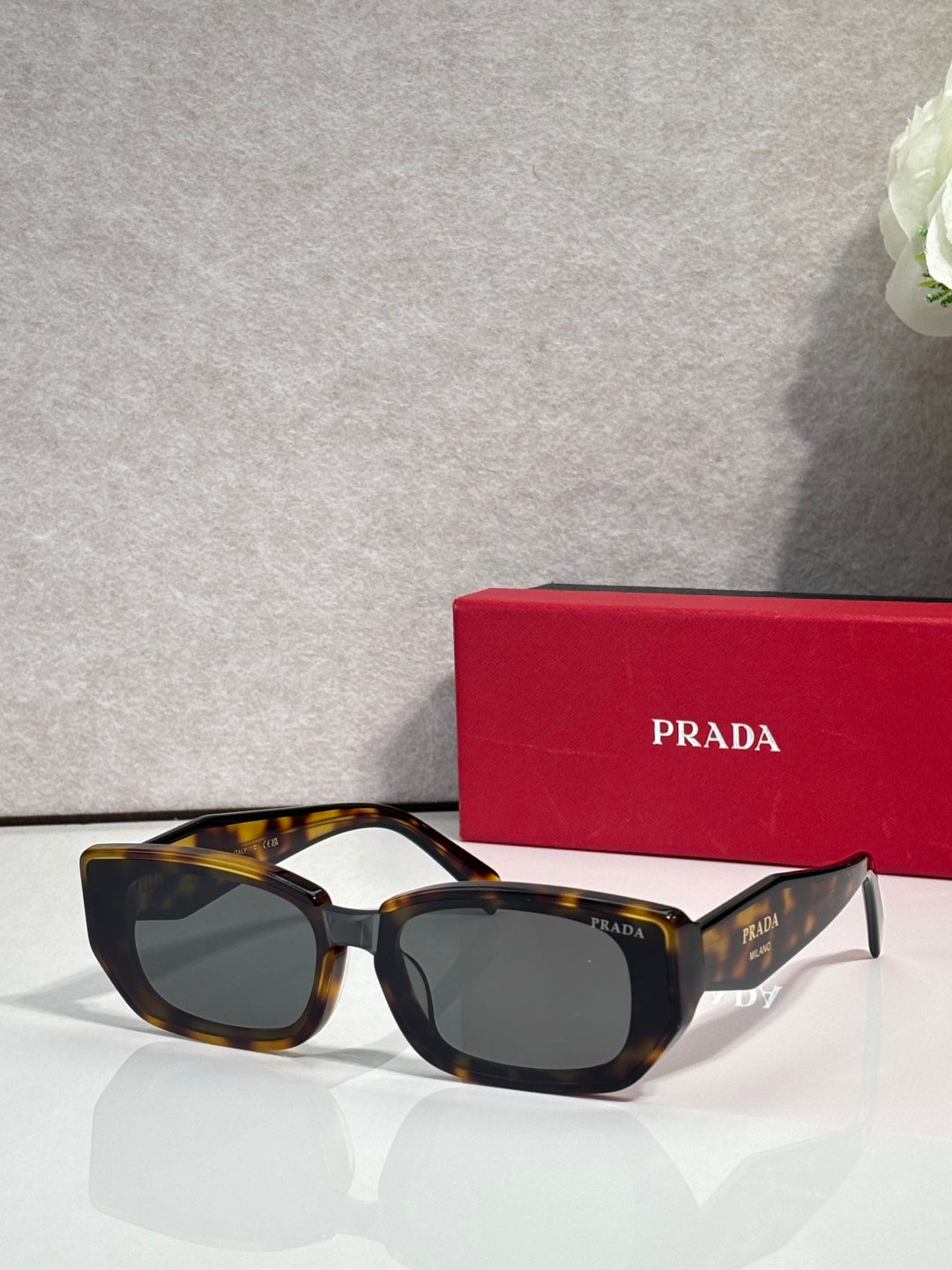 Prada sunglasses with tortoise frame and dark tinted lenses, cat-eye style