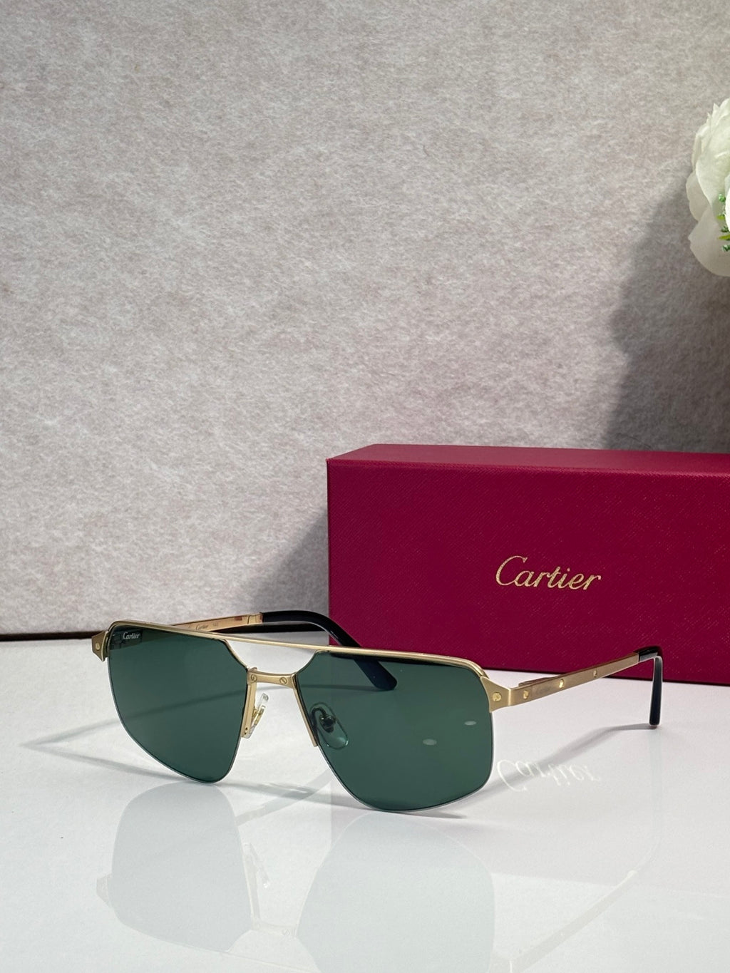 Sunglasses with gold metal frame and dark green mirrored lenses, cat-eye style