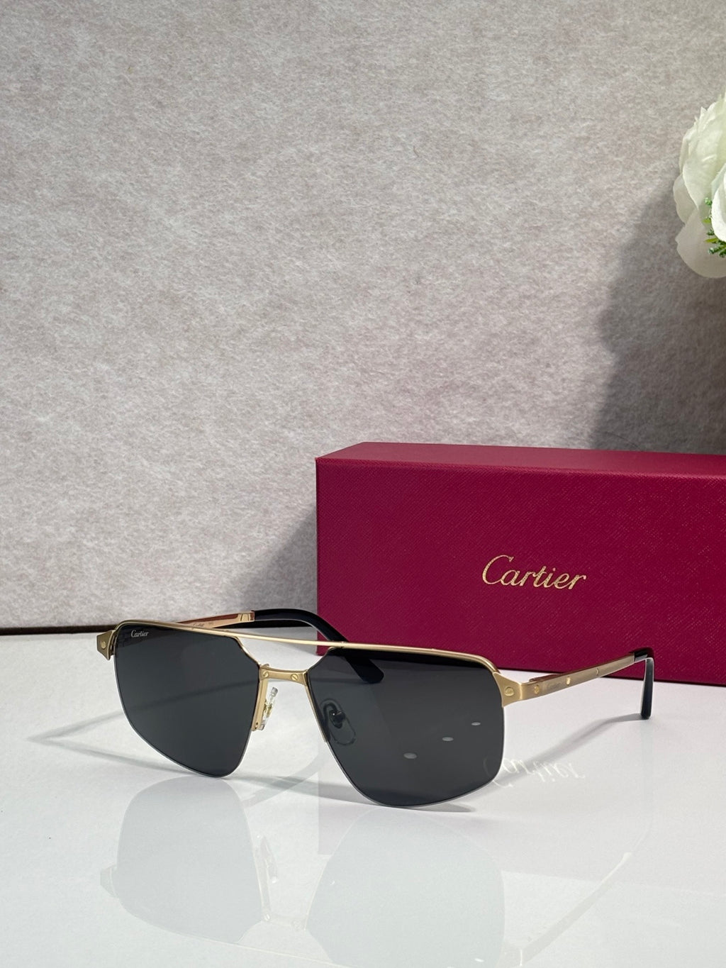 Sunglasses with gold metal frame and dark gray mirrored lenses, cat-eye shape