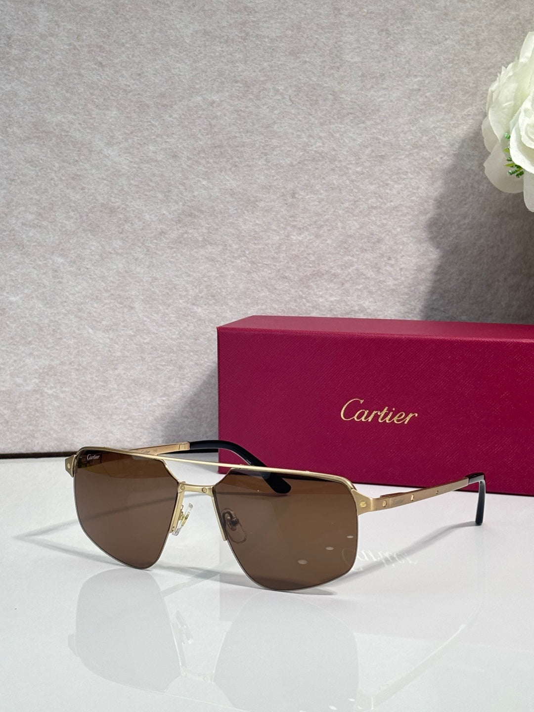 Sunglasses with gold metal frame and brown mirrored lenses, cat-eye style