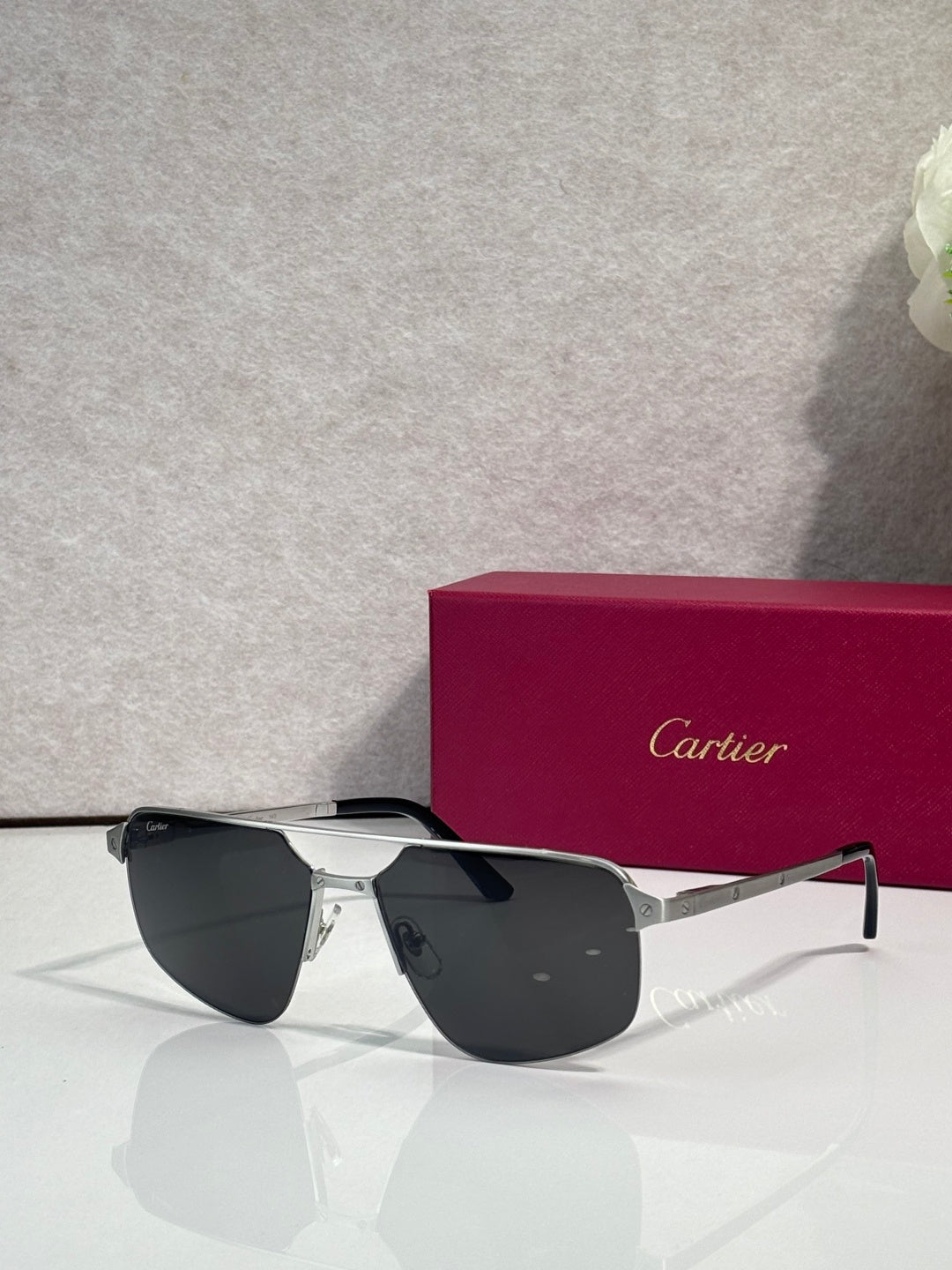 Sunglasses with silver metal frame and dark blue mirrored lenses, cat-eye shape