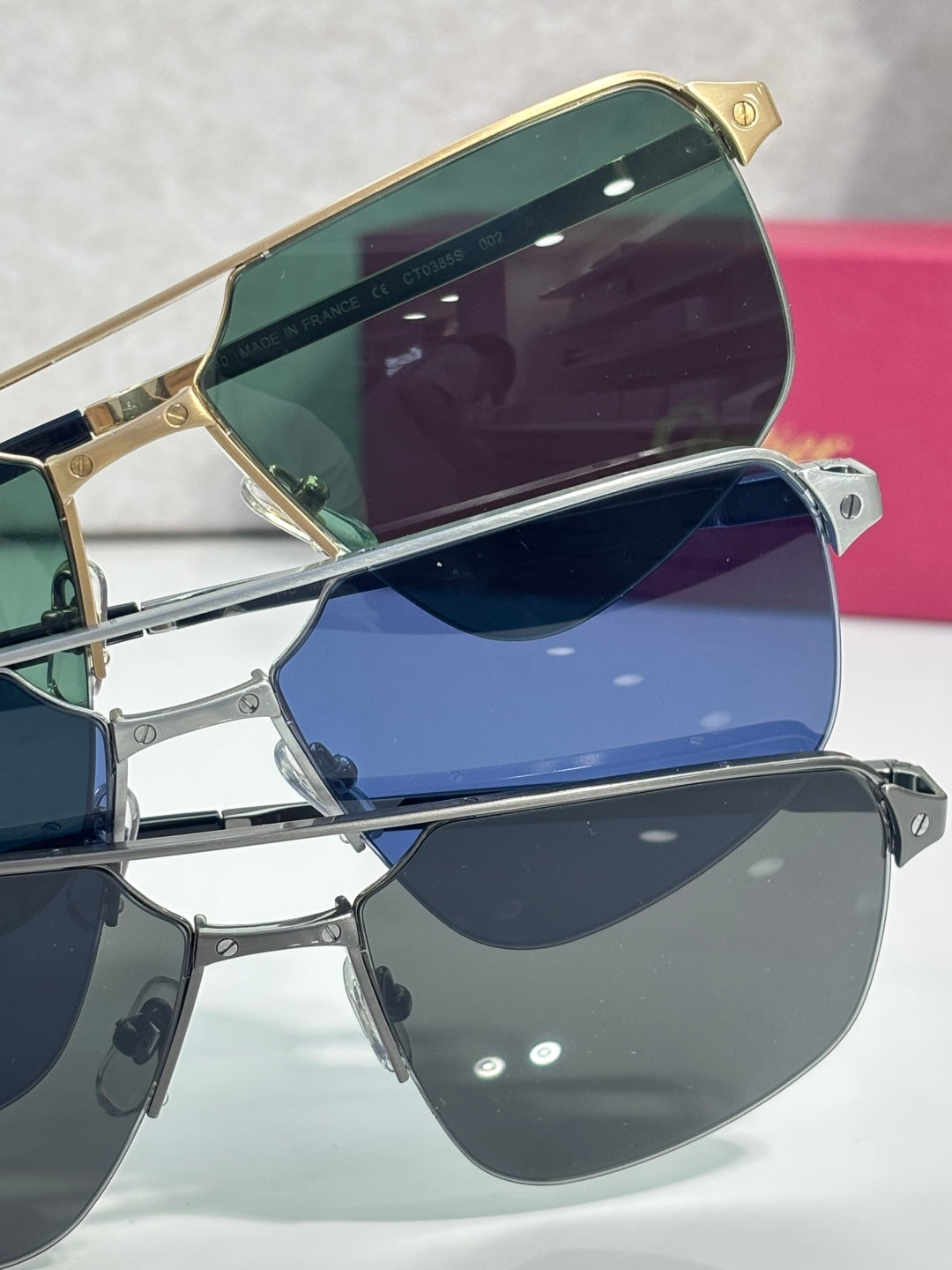Sunglasses close-up stack with gold and dark frames and mirrored blue lenses