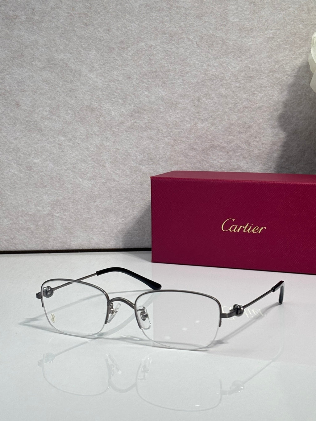 Cartier glasses with clear lenses, silver metal frame and dark arms