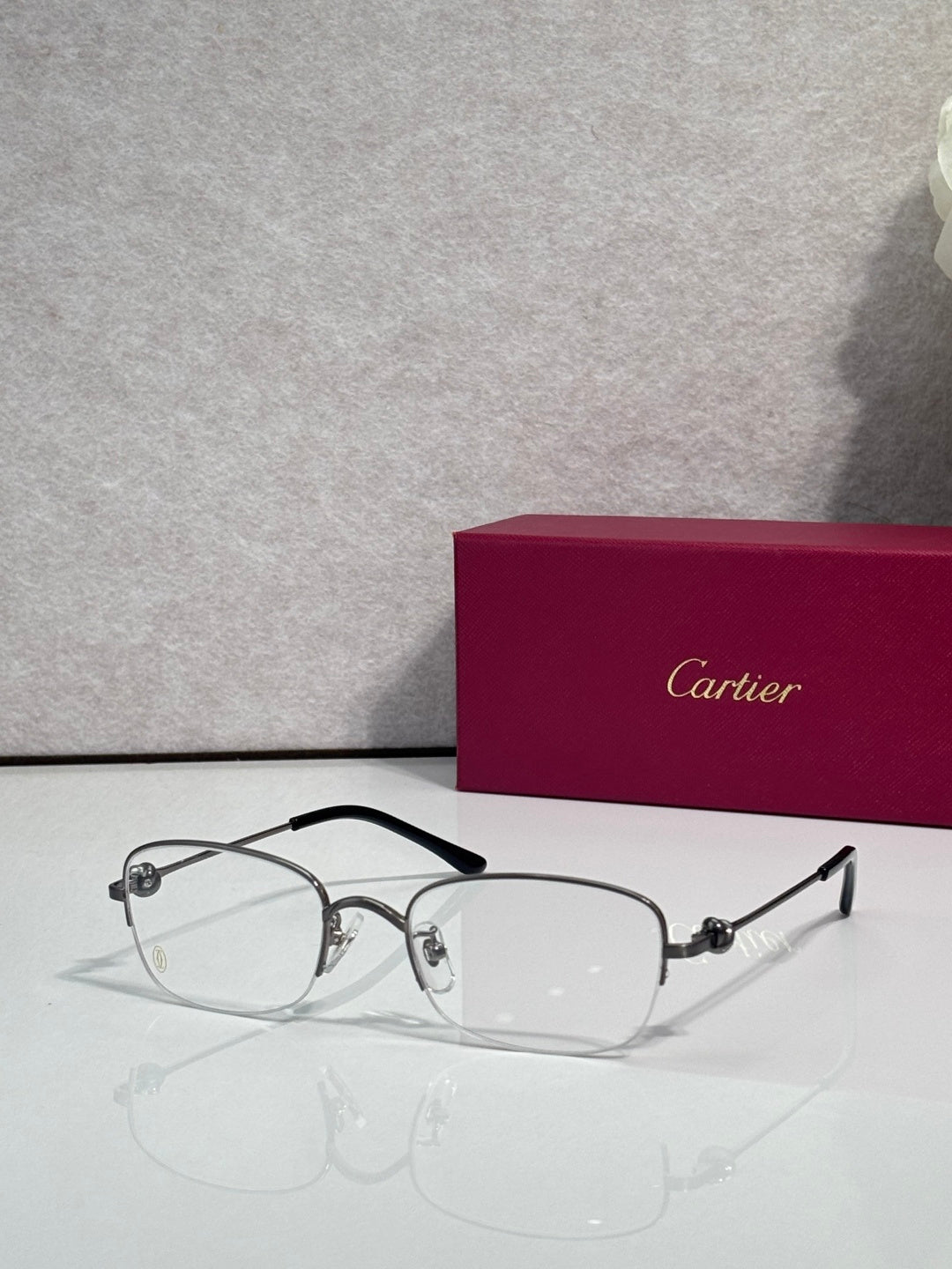 Cartier glasses with clear lenses, silver metal frame and dark arms