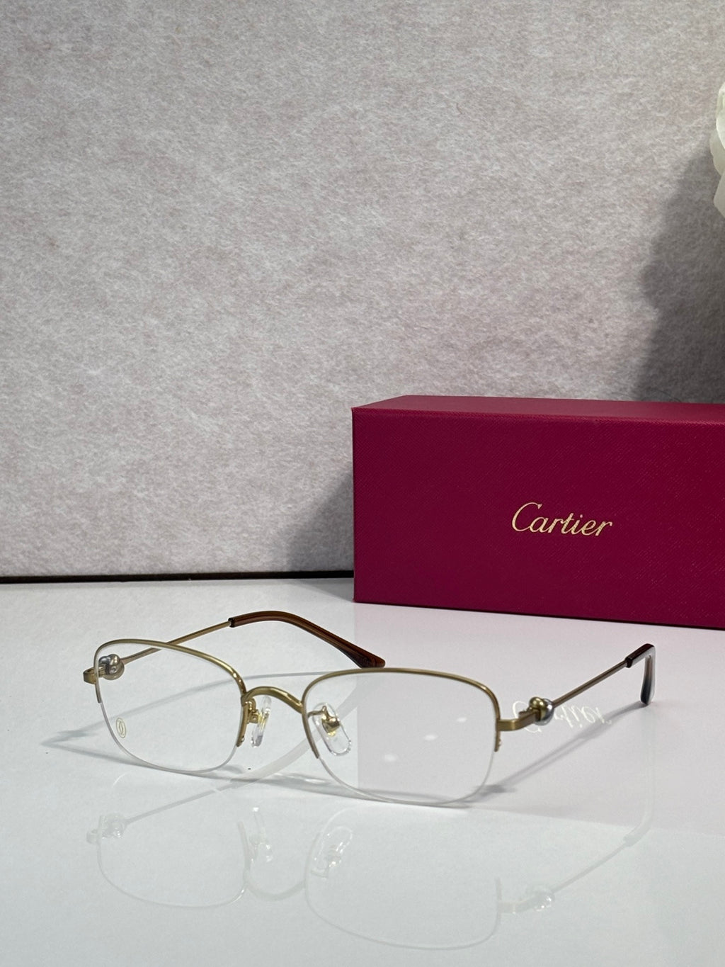 Cartier glasses with clear lenses, gold metal frame and dark temples