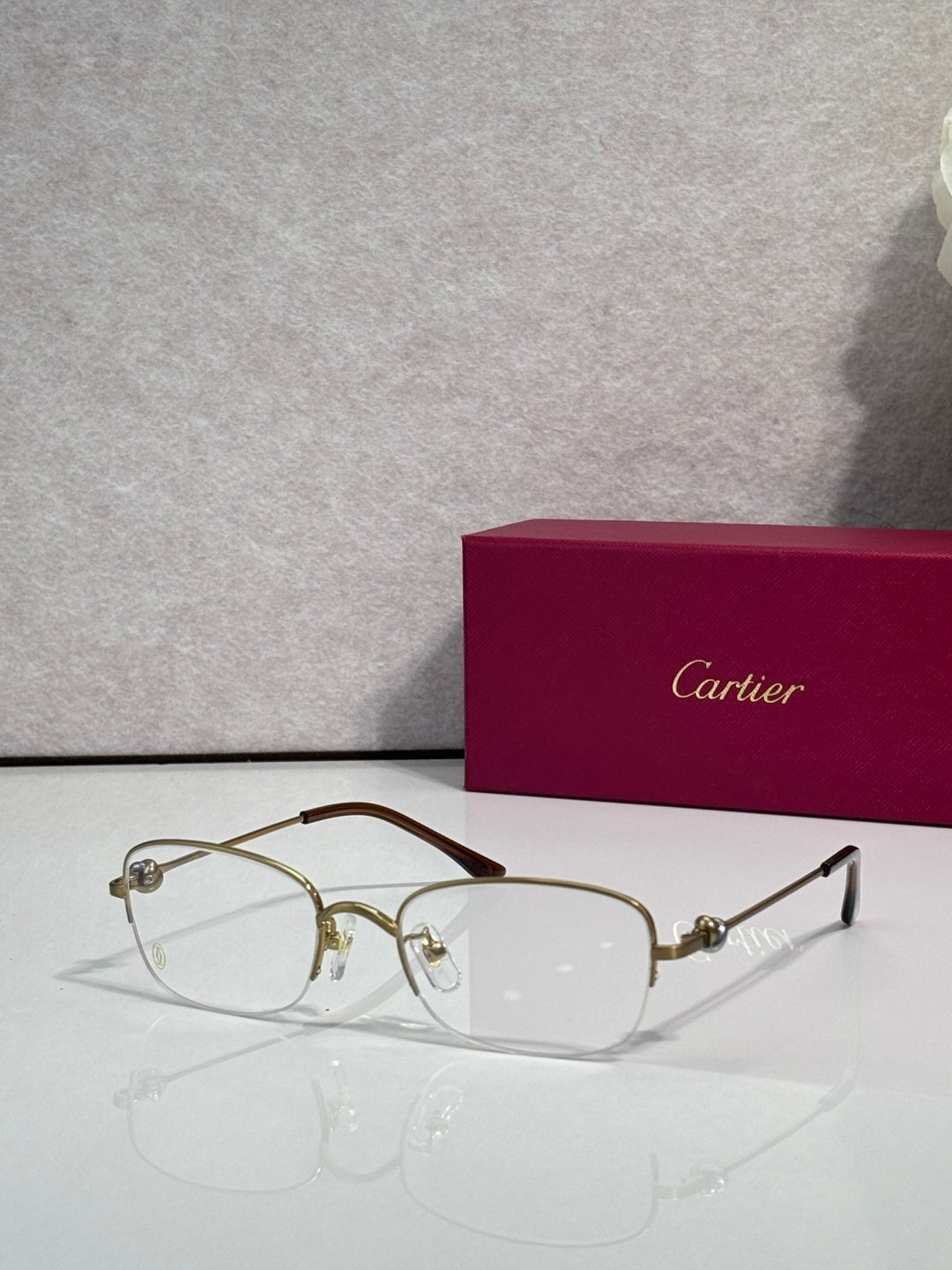 Cartier glasses with clear lenses, gold metal frame and dark temples