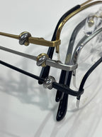 Cartier glasses close-up: dark arms with gold hinge hardware and clear lenses