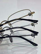 Cartier glasses close-up: multiple dark and gold temple frames with clear lenses
