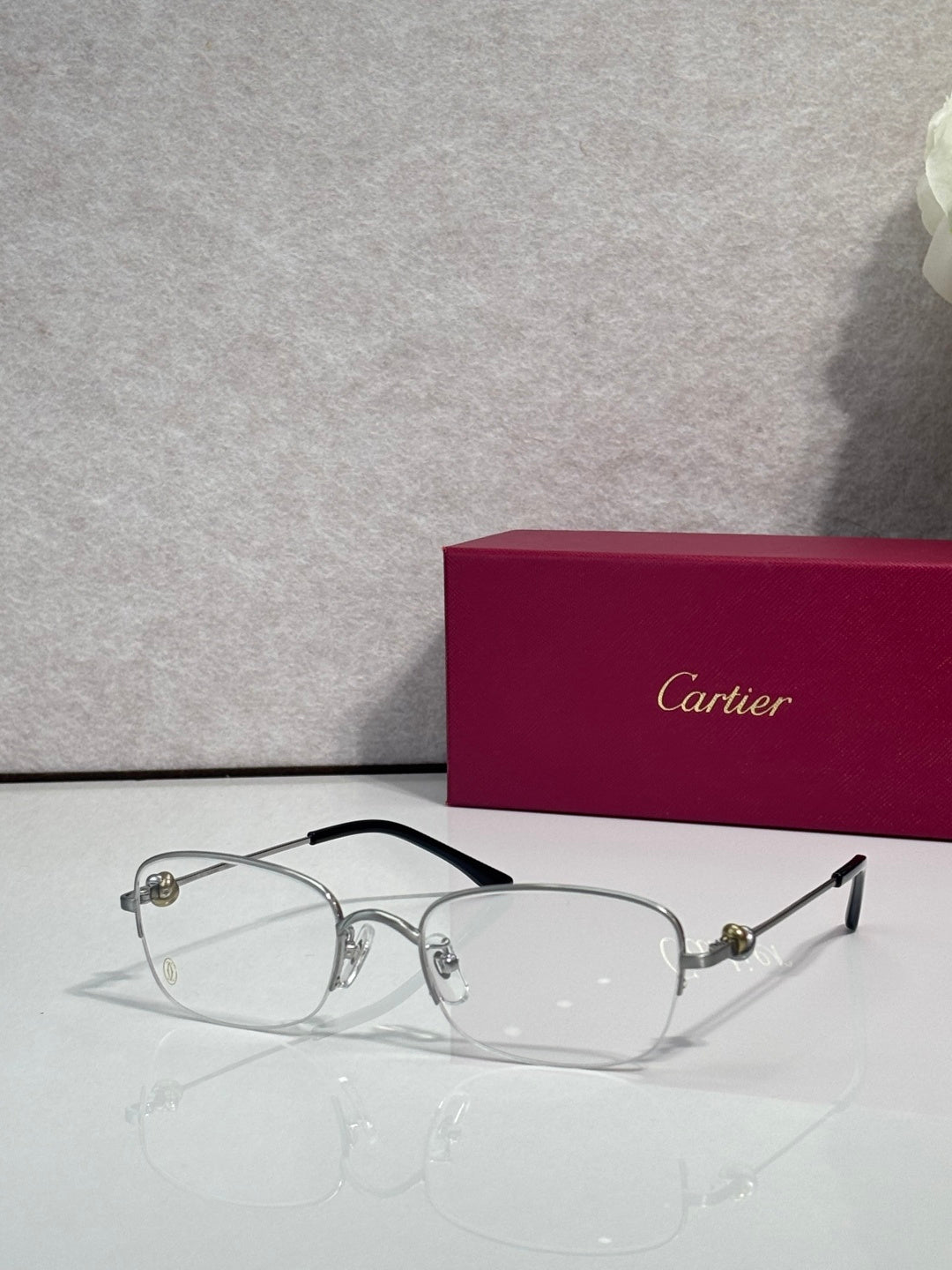 Cartier glasses with clear lenses, silver frame and black top bar