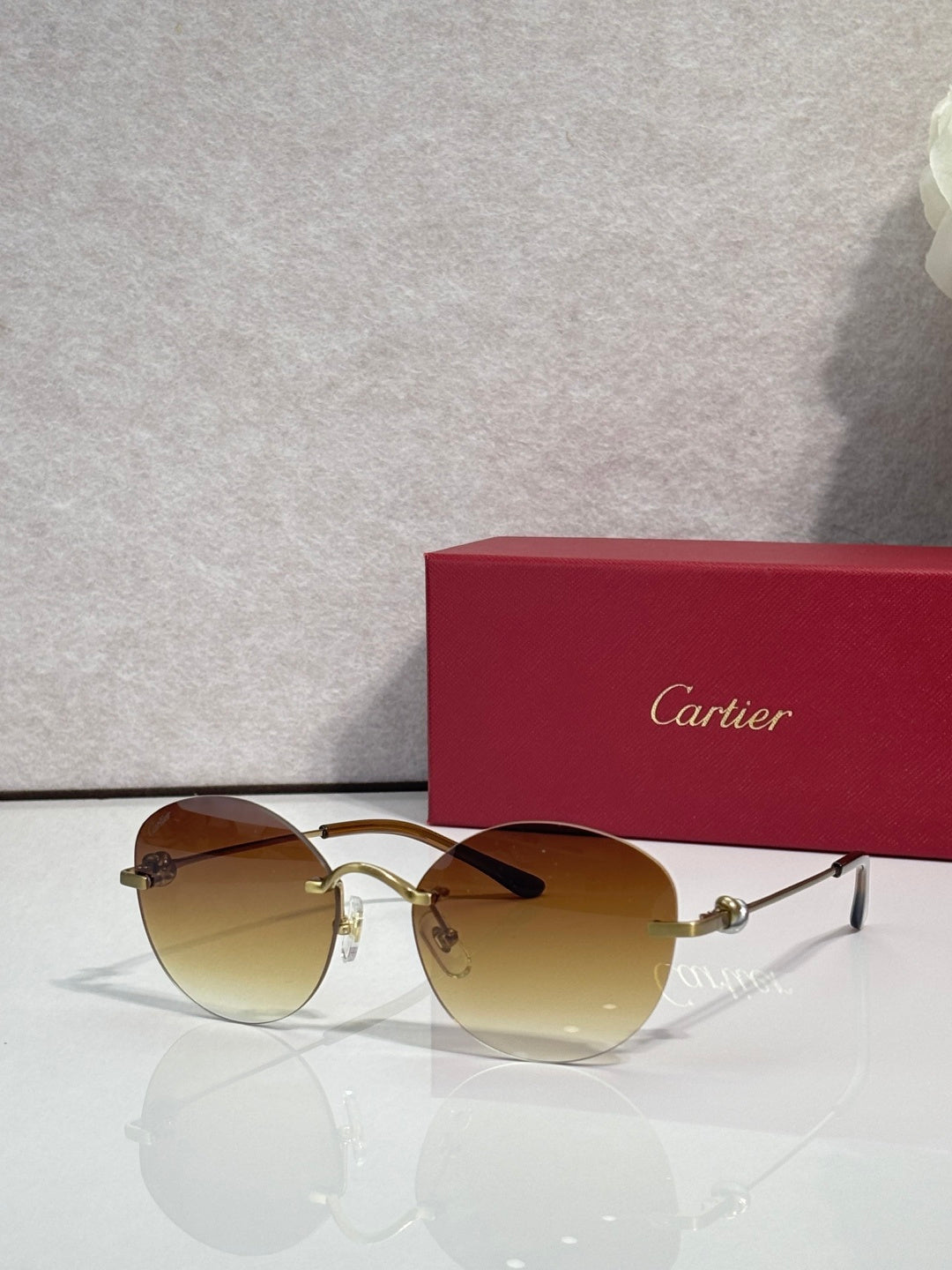 Gold sunglasses with tinted amber lenses, thin round metal frame and bridge