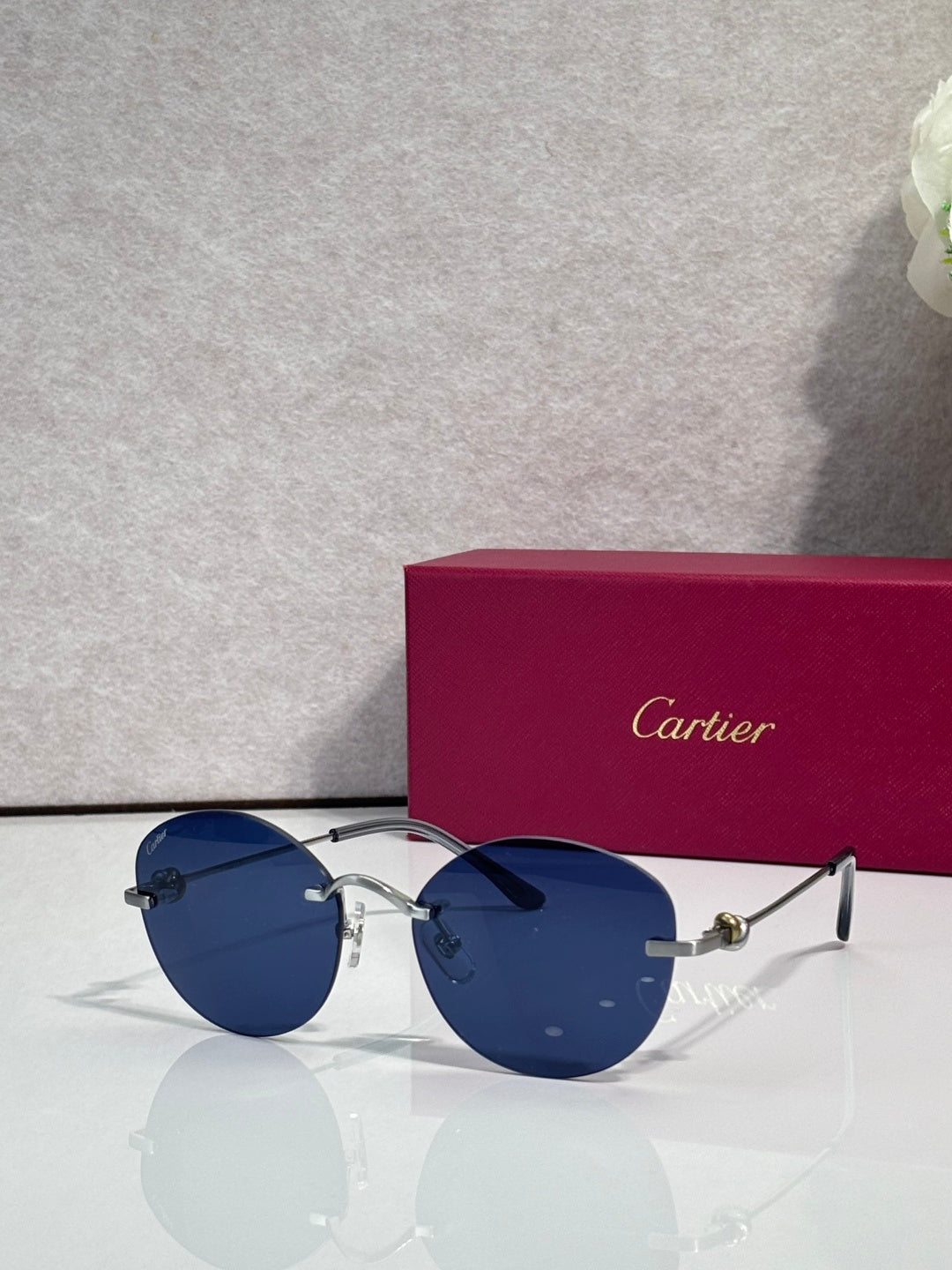 Blue sunglasses with dark lenses, round metal frame and thin black arms