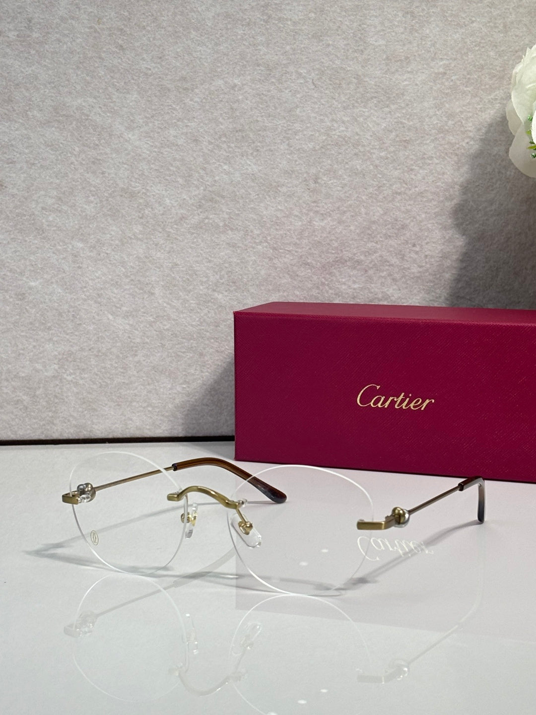 Gold eyeglasses with clear lenses and gold-tone bridge, round rectangular frame