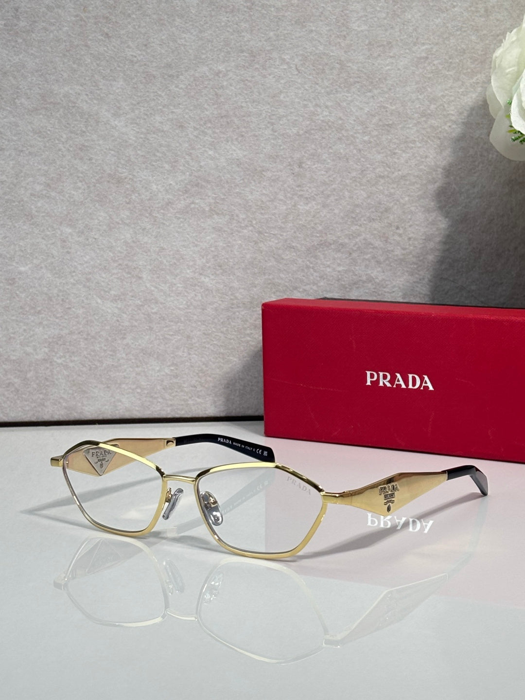 Prada optical glasses, gold metal frame, clear lenses, front view