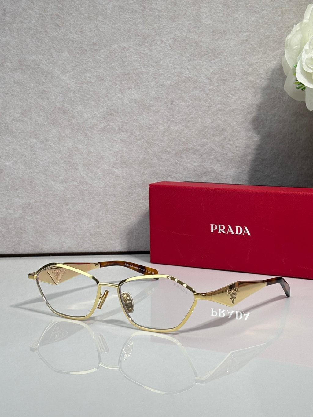 Prada optical glasses, gold metal frame with dark temple tips, side angle