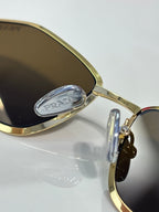 Prada optical glasses, gold metal rim and hinge detail, clear lens close-up