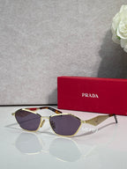 Prada cat-eye sunglasses with gold frame and dark purple lenses, logo on arms