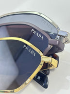 Prada sunglasses close-up with dark lenses and gold-and-silver metal frames
