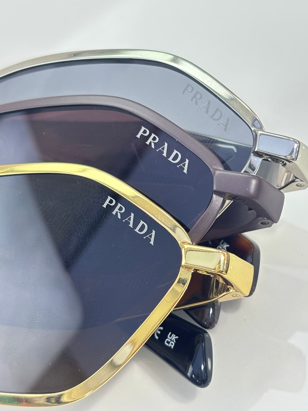 Prada sunglasses close-up with dark lenses and gold-and-silver metal frames