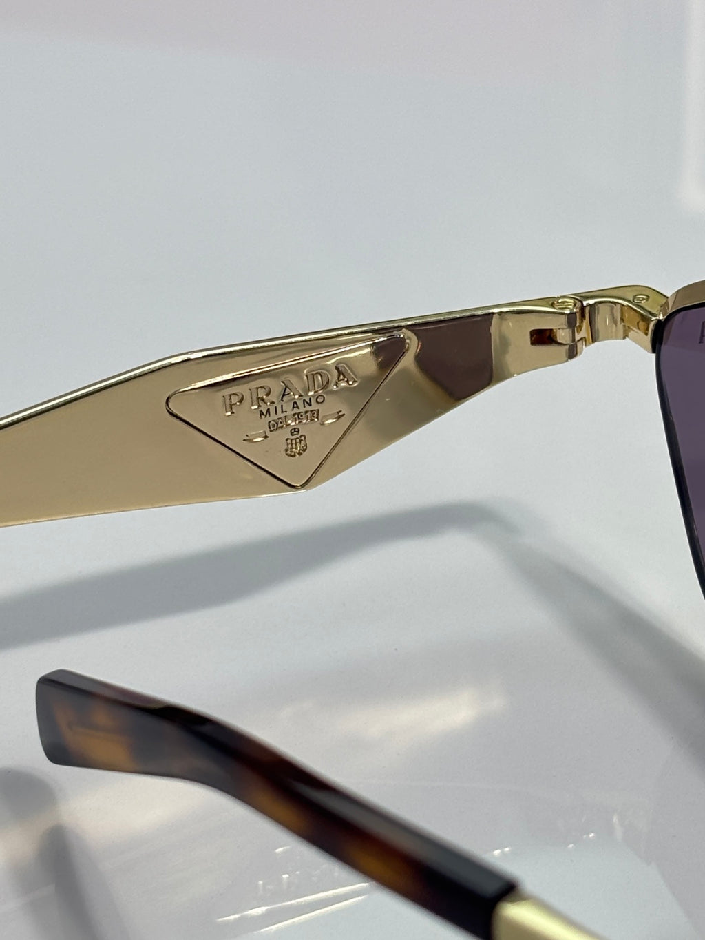 Prada sunglasses temple with PRADA MILANO engraving and gold metal details