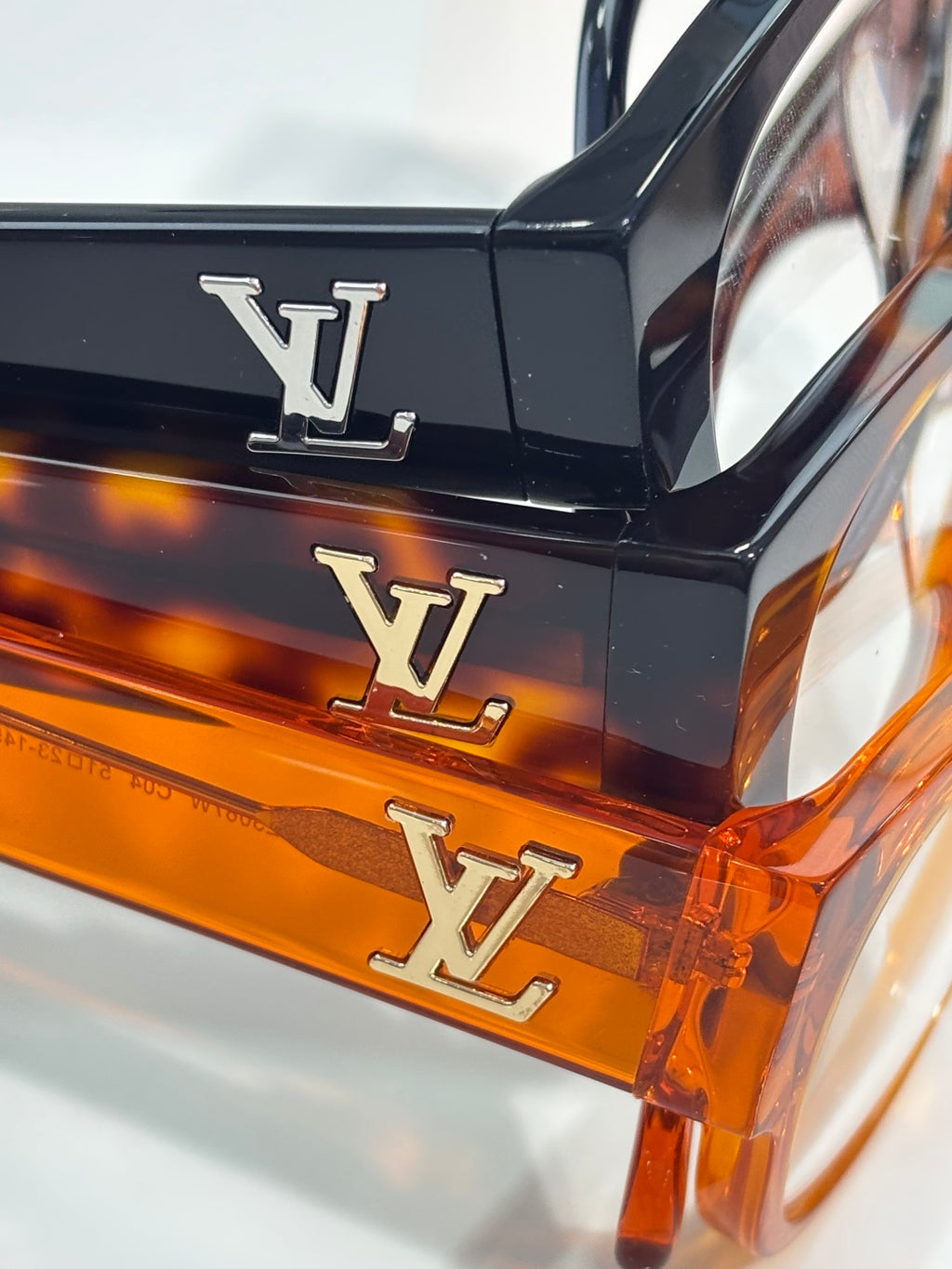Orange eyeglasses with LV monogram on black temple, clear lenses