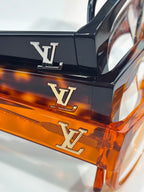 Orange eyeglasses with LV monogram on black temple, clear lenses