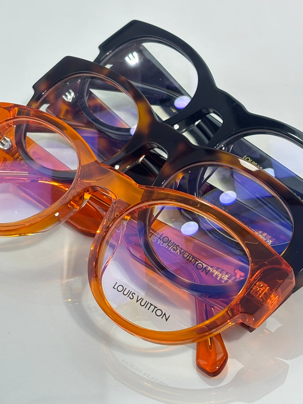 Round eyeglasses in blue-black and orange tortoise frames, clear lenses
